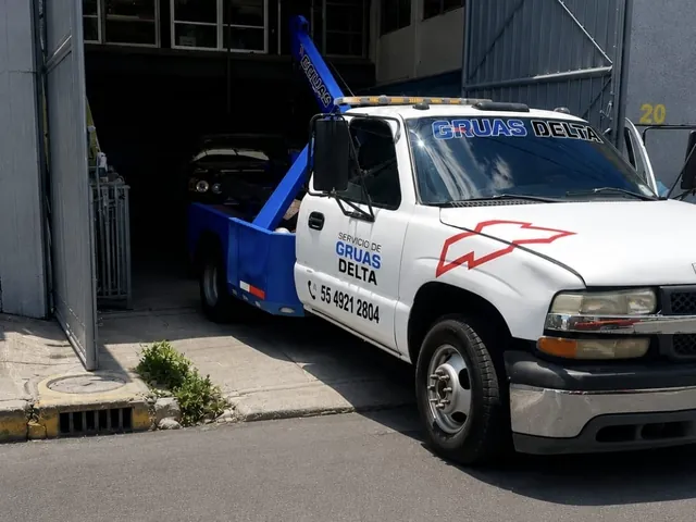 Grúa de Grúas Delta entrando a un taller con un vehículo remolcado
